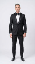 Man wearing a black tuxedo with a white shirt and black bow tie on a white background