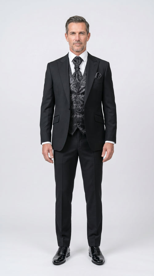 Man wearing a black suit with a patterned vest on a white background