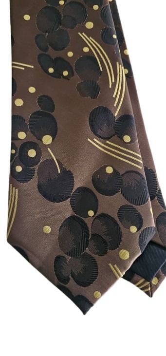 Patterned tie with black and gold design on a brown background
