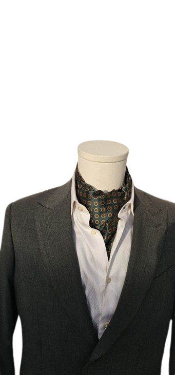 Mannequin wearing a dark suit with a white shirt and patterned tie on a white background
