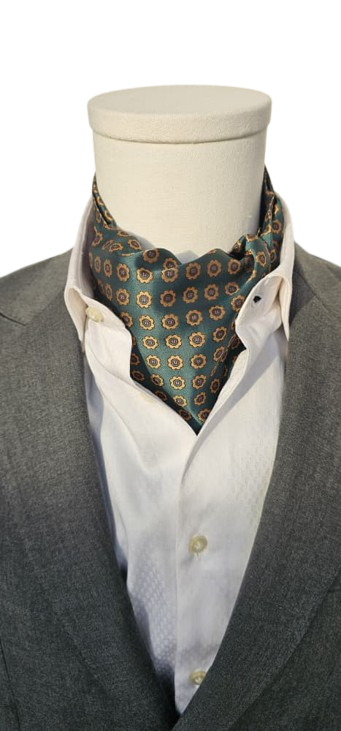 Mannequin wearing a gray suit with a white shirt and patterned cravat on a white background