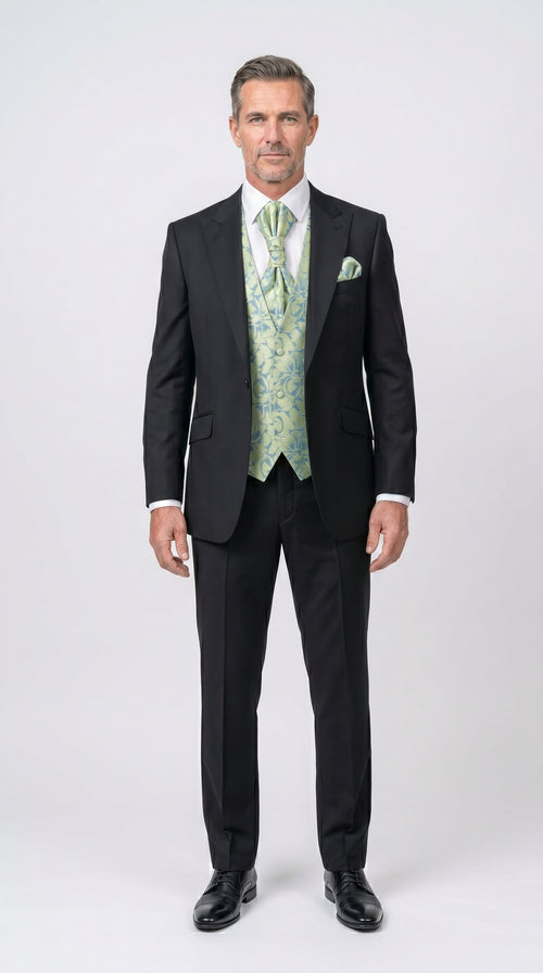 Man wearing a black suit with a green vest and tie on a white background