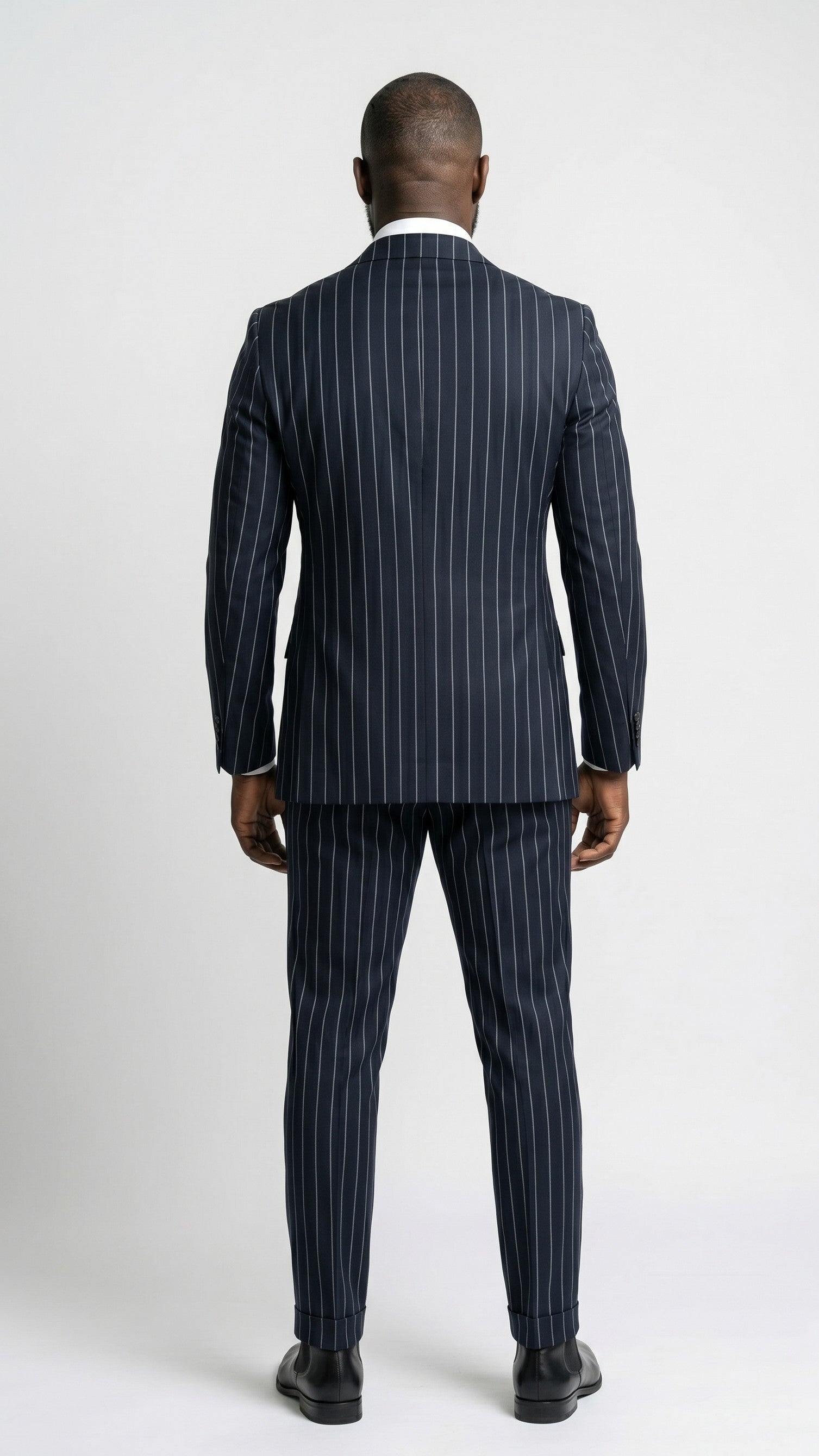 Man wearing a navy pinstripe suit on a white background