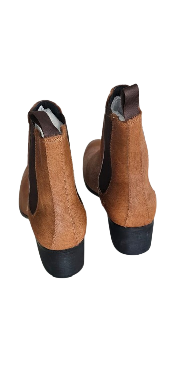 Pair of brown ankle boots with black soles on a white background