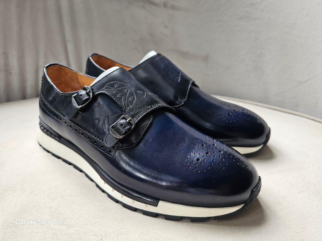 Pair of navy blue shoes with a buckle on a light surface.