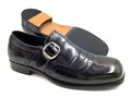 Black leather dress shoe with a buckle on a white background