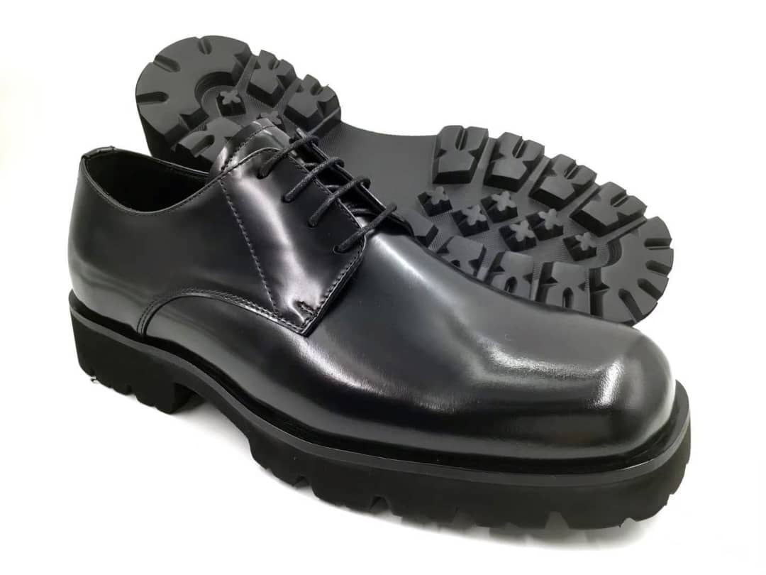 Black leather shoe with a thick sole on a white background