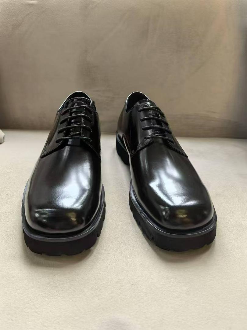 Pair of black dress shoes on a neutral background