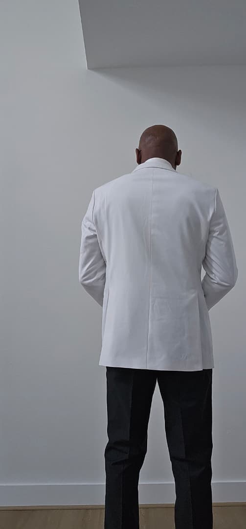 White tuxedo with black lapels and bow tie on a mannequin, with close-up details.