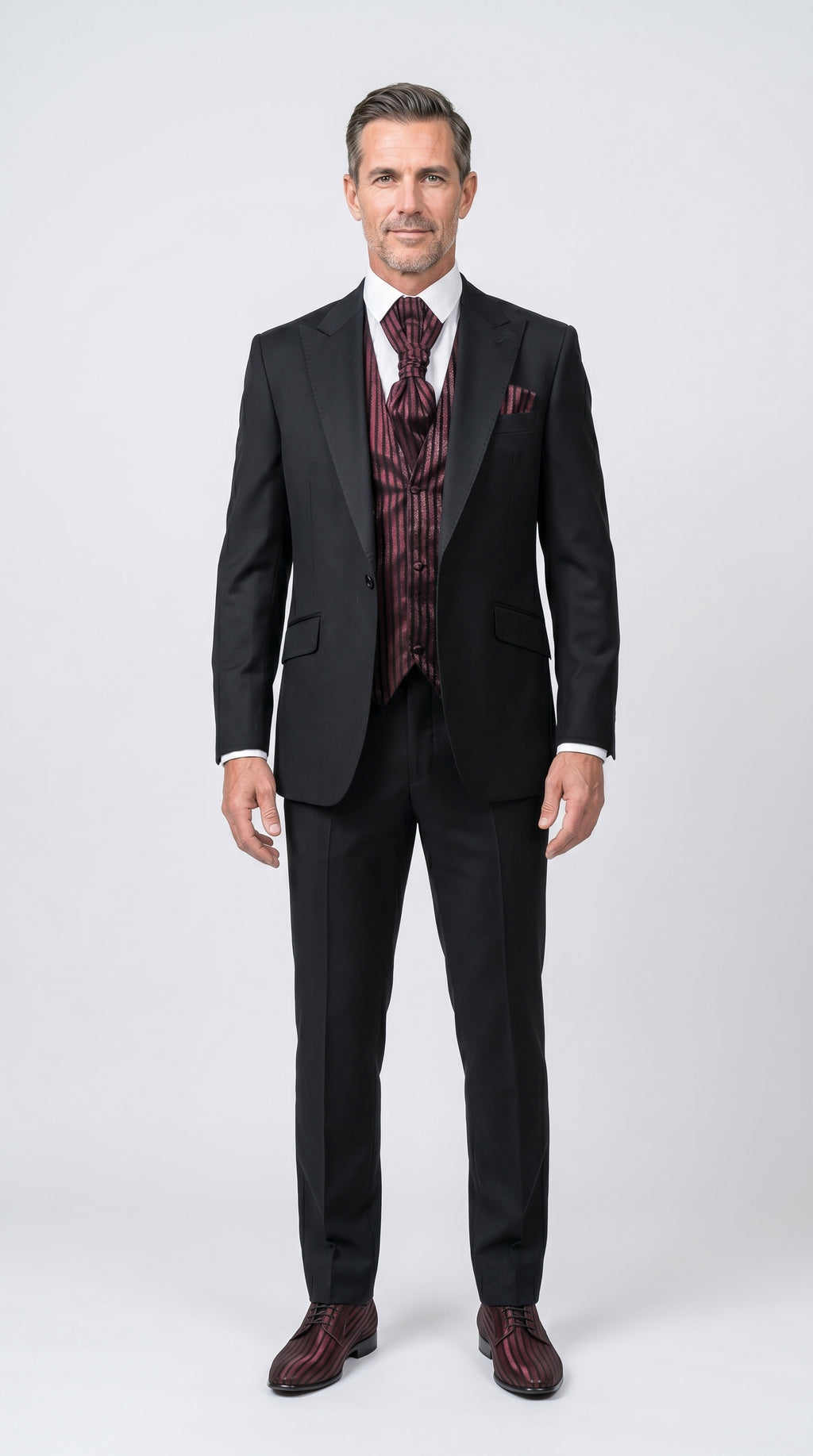 Man wearing a black suit with a patterned vest on a white background