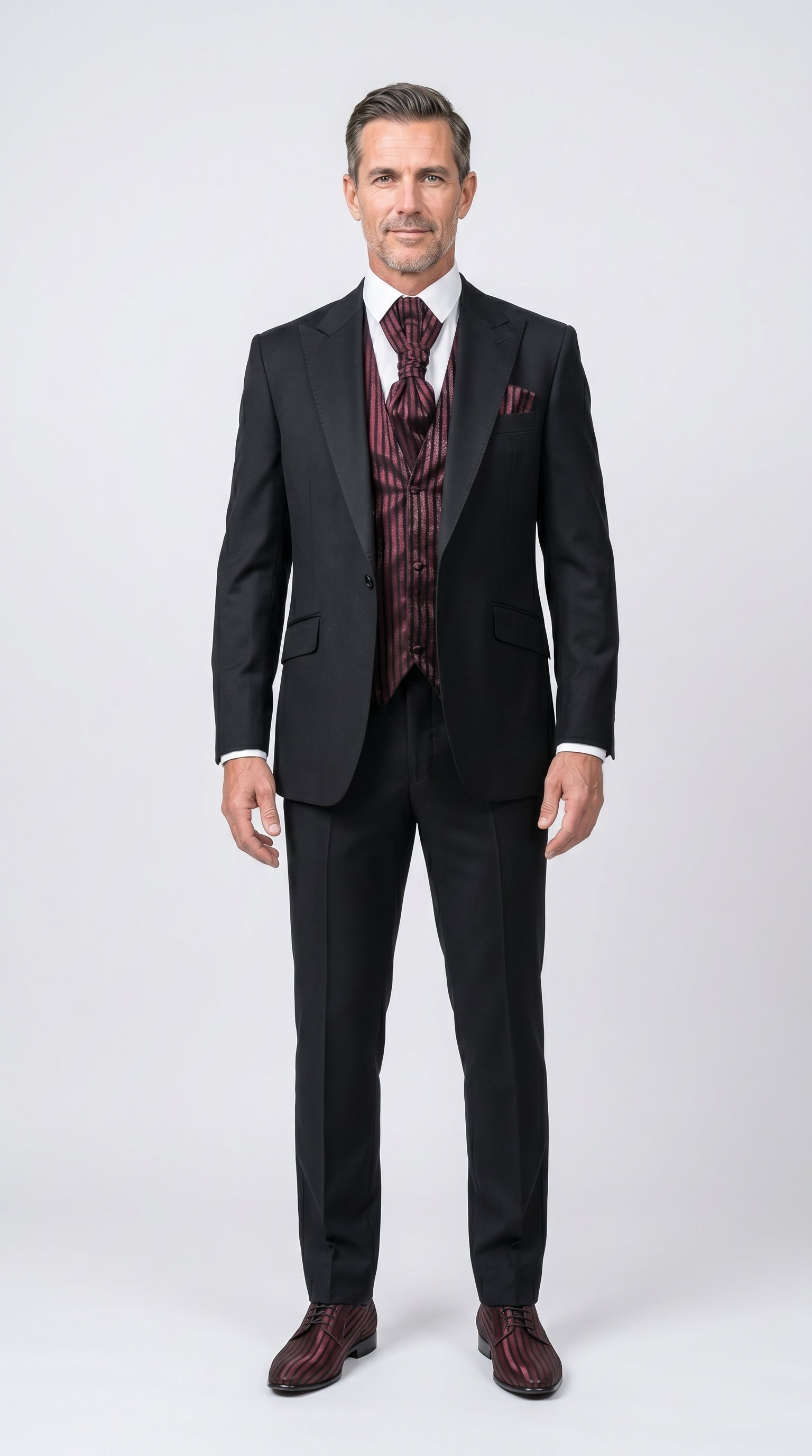 Man wearing a black suit with a patterned vest on a white background